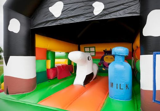 Multifun koe springkasteel met verschillende obstakels, een  glijbaan en 3D figuur van een koe op het dak bestellen voor kids. Koop online springkastelen bij JB Inflatables Nederland